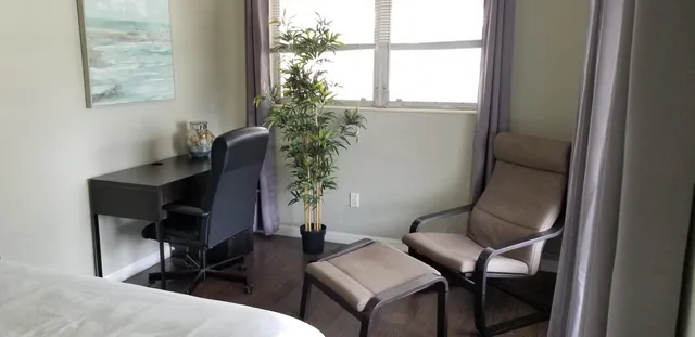 a view of a workspace with furniture and a window