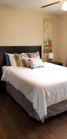 a bedroom with a bed and wooden floor