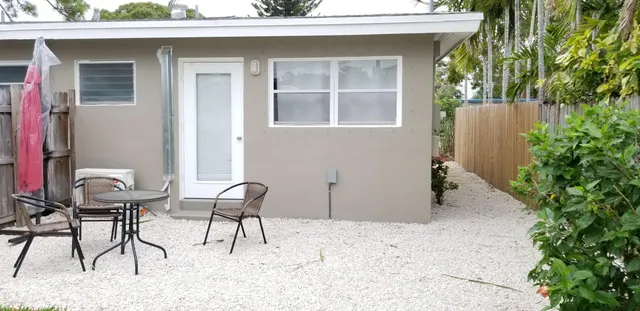 a backyard of a house with table and chairs