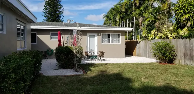 a view of house with patio outdoor seating and covered with trees