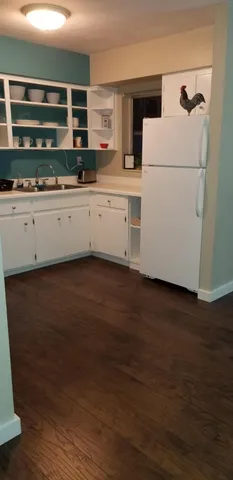 a kitchen with a sink and wooden floor