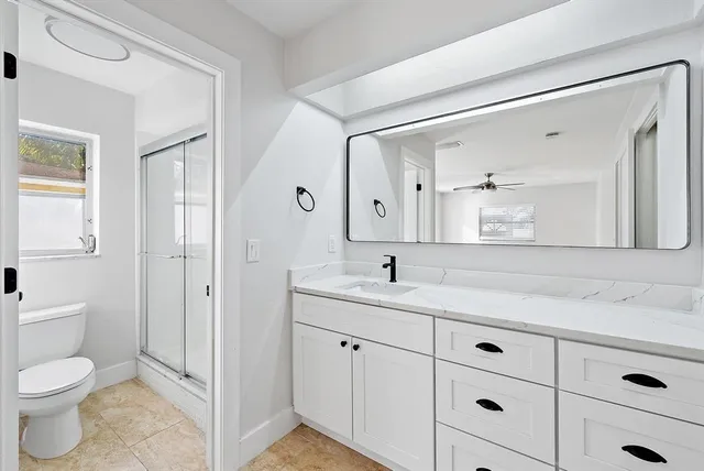 a spacious bathroom with a granite countertop sink mirror and toilet
