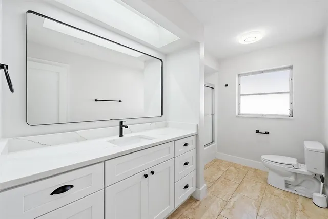 a bathroom with a toilet a sink and mirror