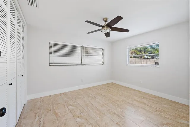 a view of empty room with wooden floor and window