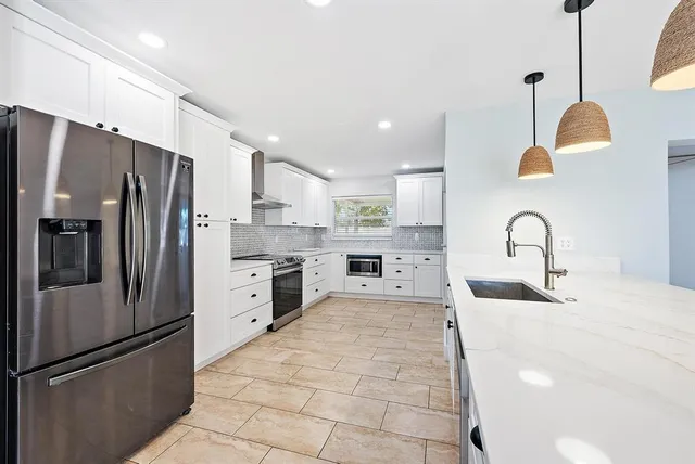 a kitchen with stainless steel appliances a refrigerator sink and cabinets