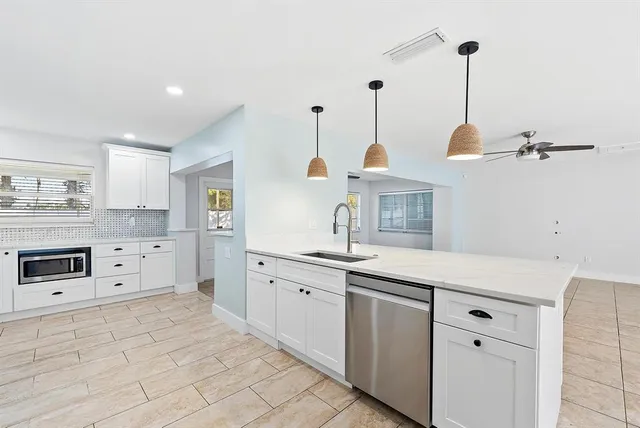 a kitchen with kitchen island white cabinets and white appliances