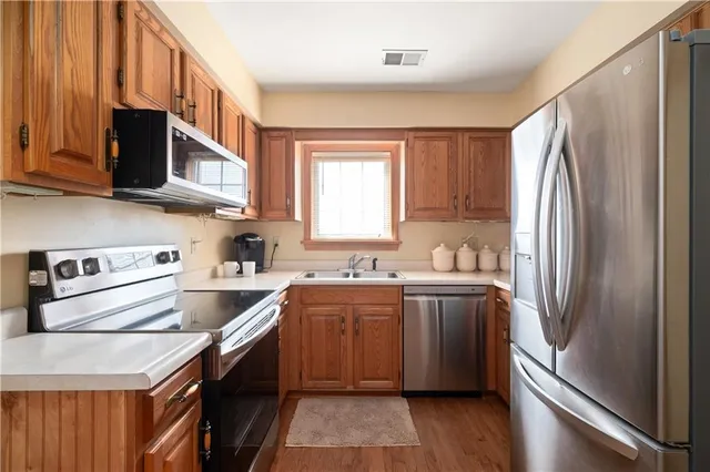 a kitchen with stainless steel appliances a sink stove and refrigerator
