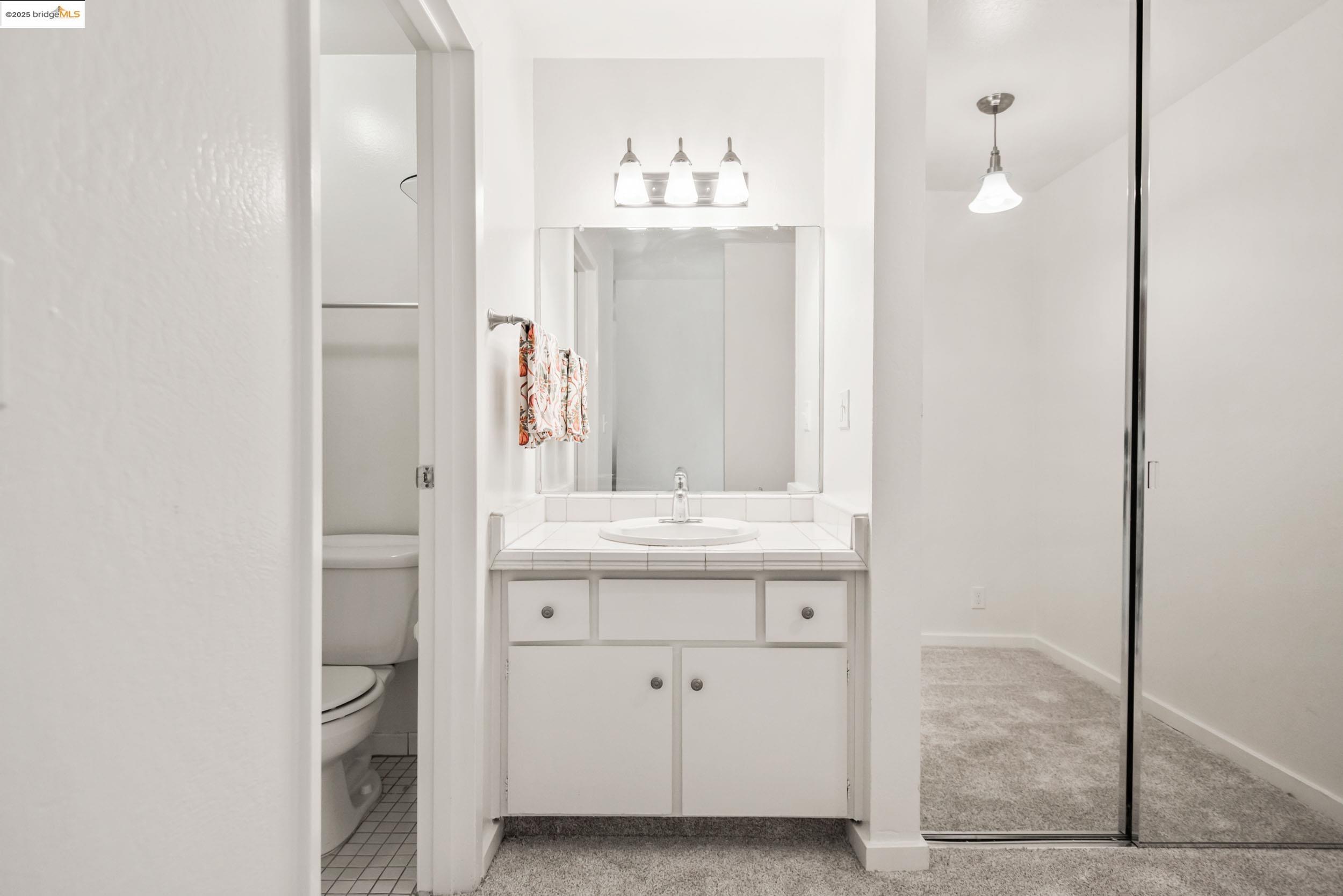 288 Whitmore Street, Unit 310B Oakland, CA 94611 - Photo 19 of 37 a bathroom with a granite countertop sink and a mirror