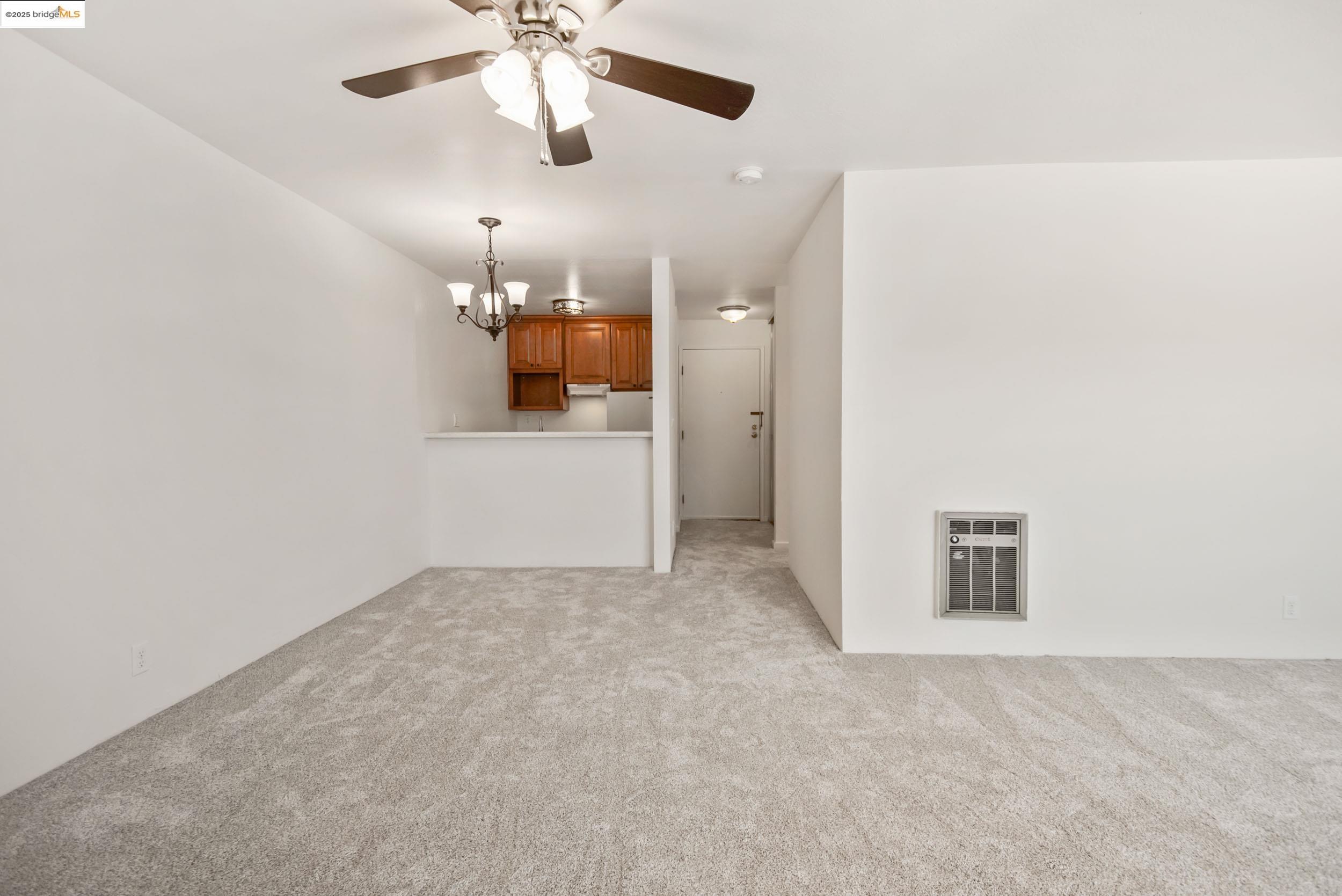 288 Whitmore Street, Unit 310B Oakland, CA 94611 - Photo 3 of 37 en empty room with chandelier fan and kitchen view