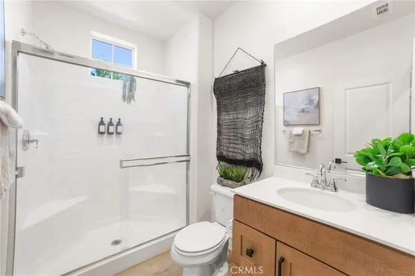 a bathroom with a sink a mirror a toilet and shower