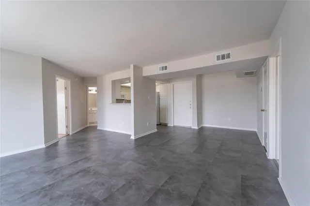 a view of an empty room with window and fireplace