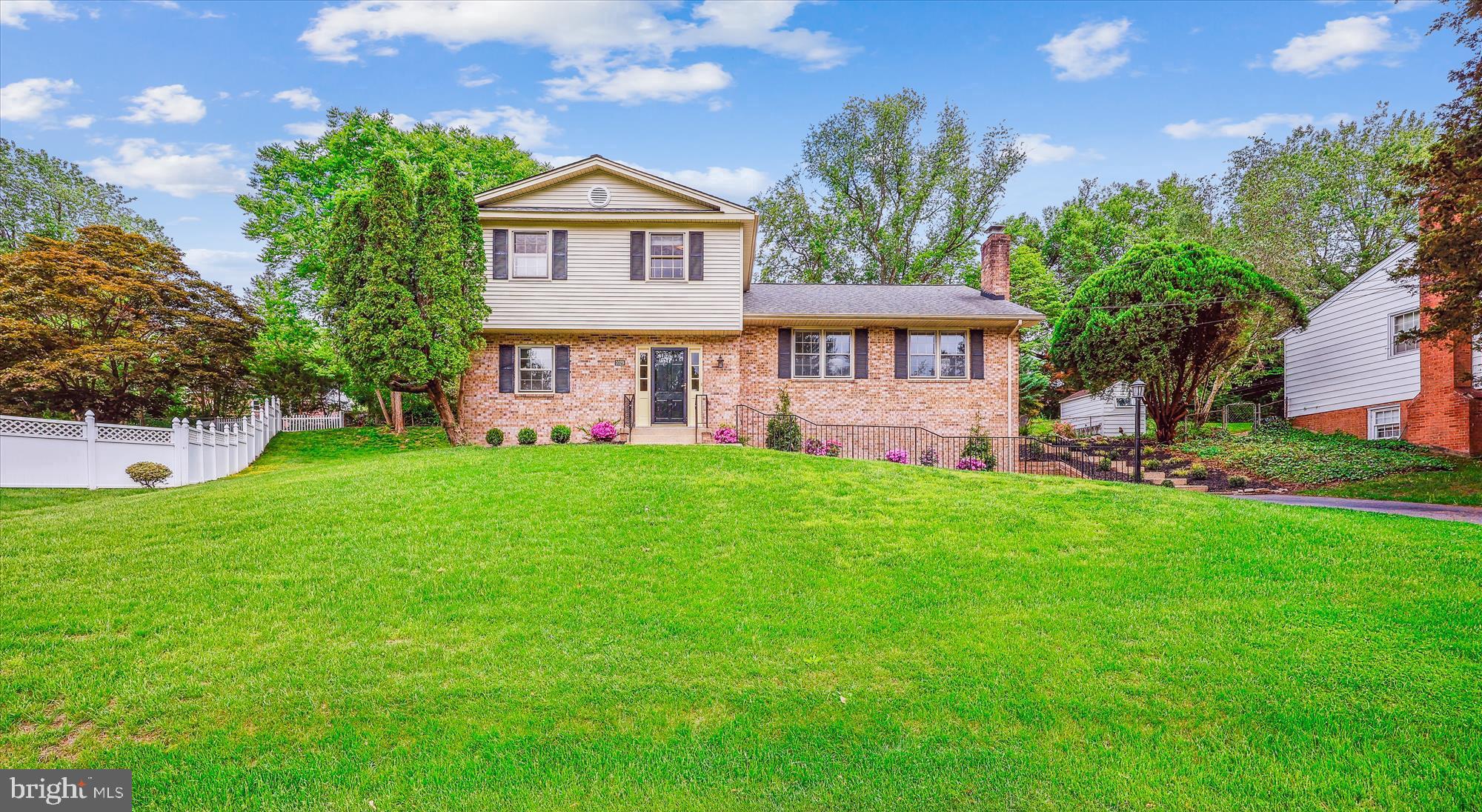 a front view of a house with a garden and yard