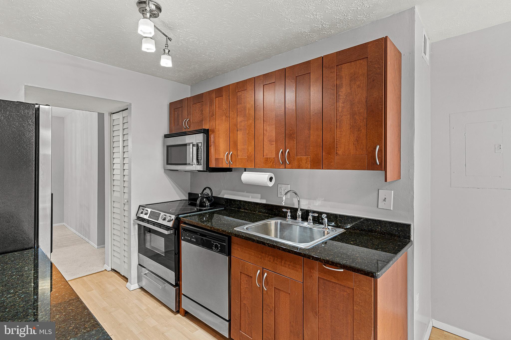 8005 Mandan Road, Unit 302 Greenbelt, MD 20770 - Photo 11 of 22 a kitchen with a sink and a stove top oven