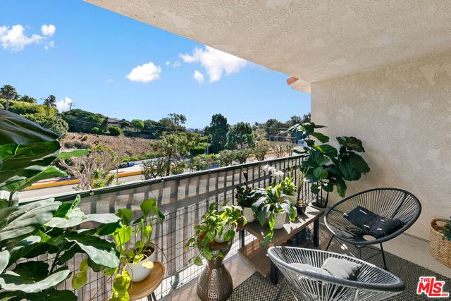 a view of a balcony with furniture and a potted plant