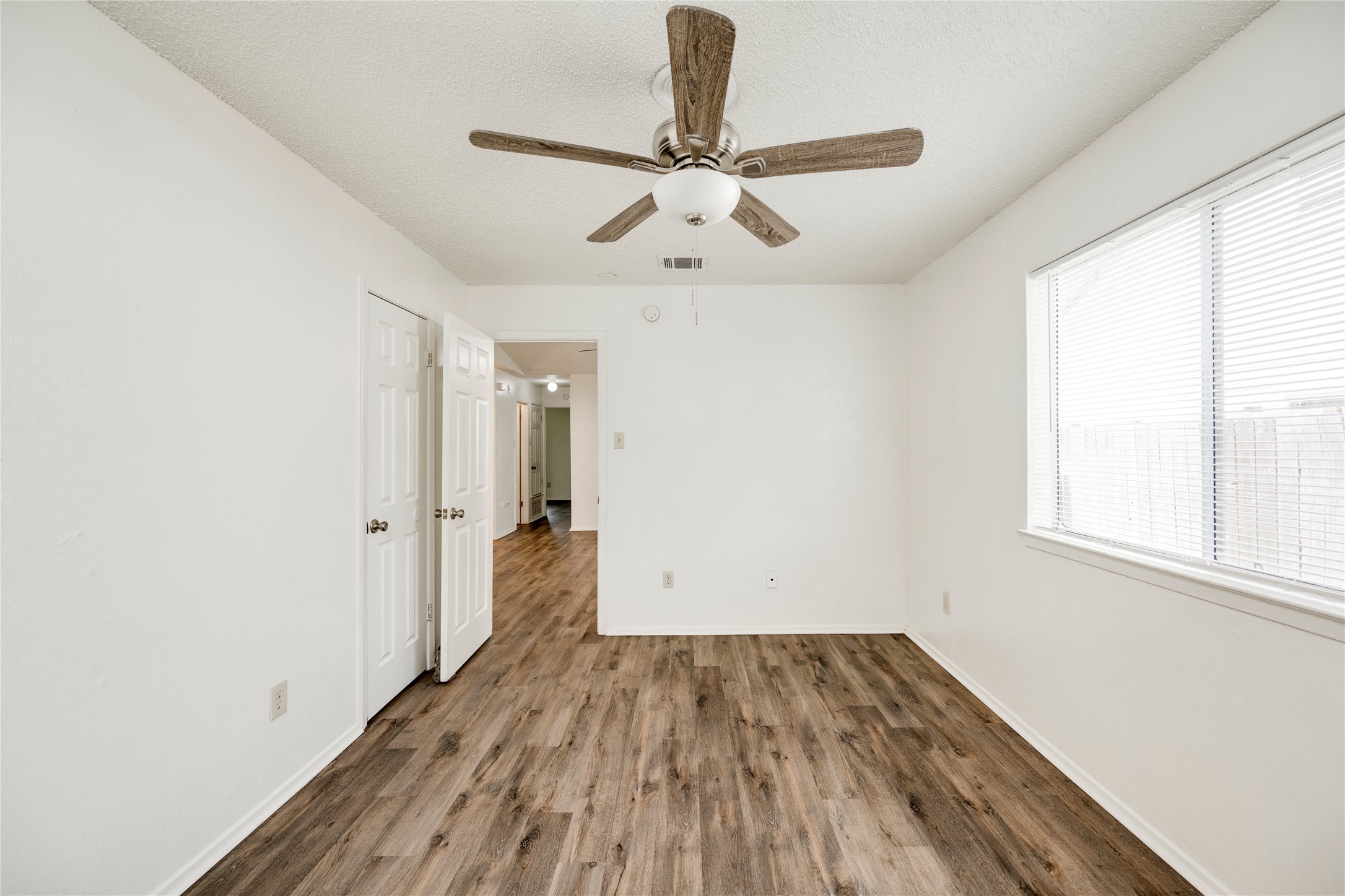 7918 West Gate Boulevard Austin, TX 78745 - Photo 13 of 31 A quiet bedroom retreat with wood-look flooring and a modern ceiling fan for year-round comfort.