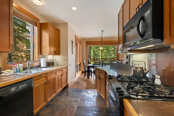 a kitchen with lots of counter top space a sink appliances and cabinets