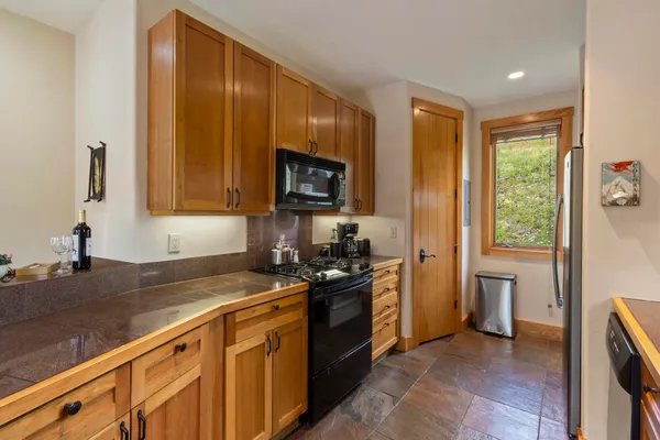 a kitchen with stainless steel appliances granite countertop a stove a sink and a refrigerator