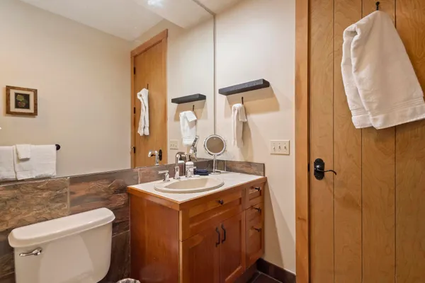a bathroom with a sink mirror vanity and toilet