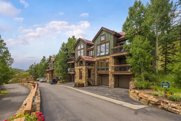 a front view of a house with a yard and parking