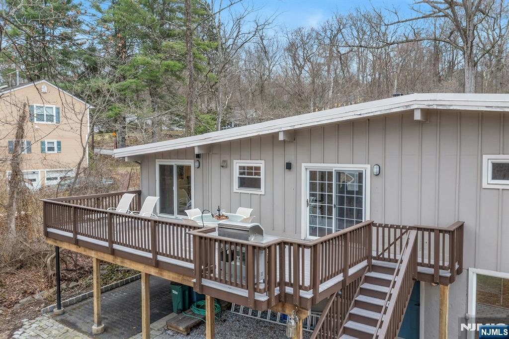 27 Bear Mountain Road Ringwood, NJ 07456 - Photo 45 of 47 a view of a house with wooden deck and furniture