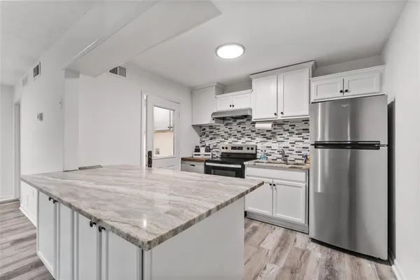 a kitchen with appliances a refrigerator and wooden cabinets