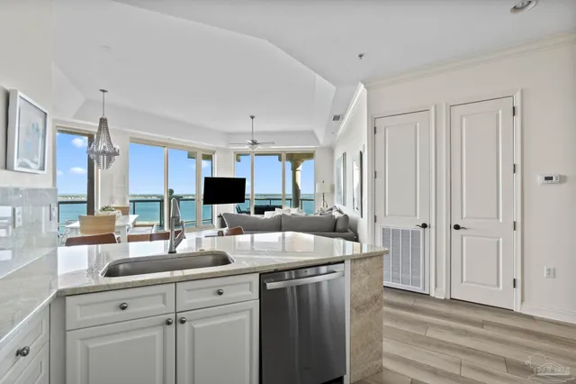 a kitchen with kitchen island granite countertop a sink cabinets and wooden floor