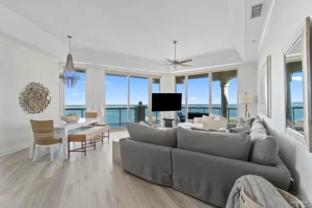 a living room with furniture a chandelier and a flat screen tv