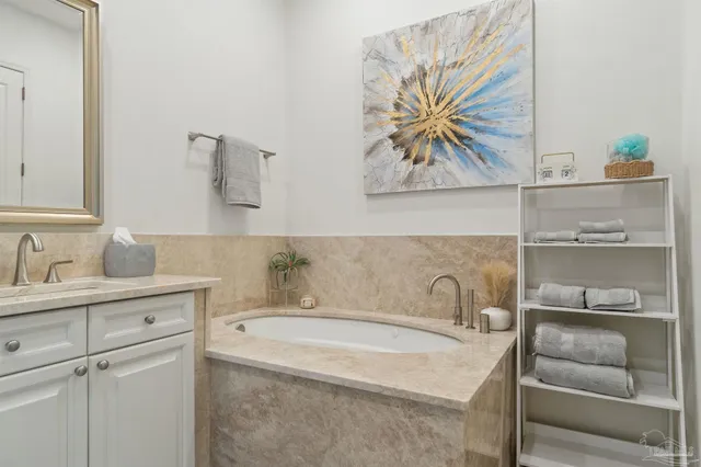 a bathroom with a tub sink and mirror