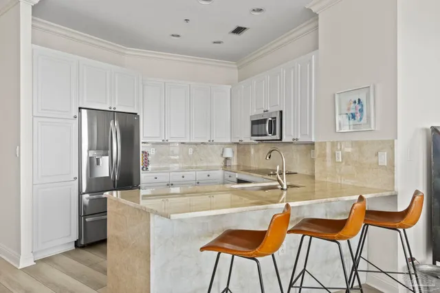 a kitchen with stainless steel appliances kitchen island granite countertop a table and chairs in it
