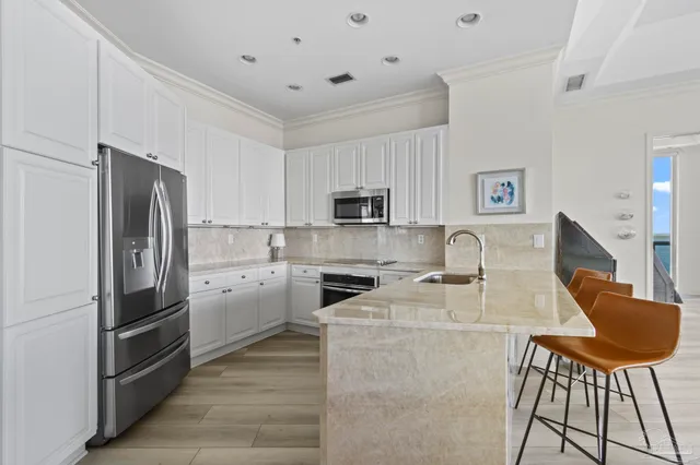 a kitchen with stainless steel appliances granite countertop a refrigerator stove microwave and sink