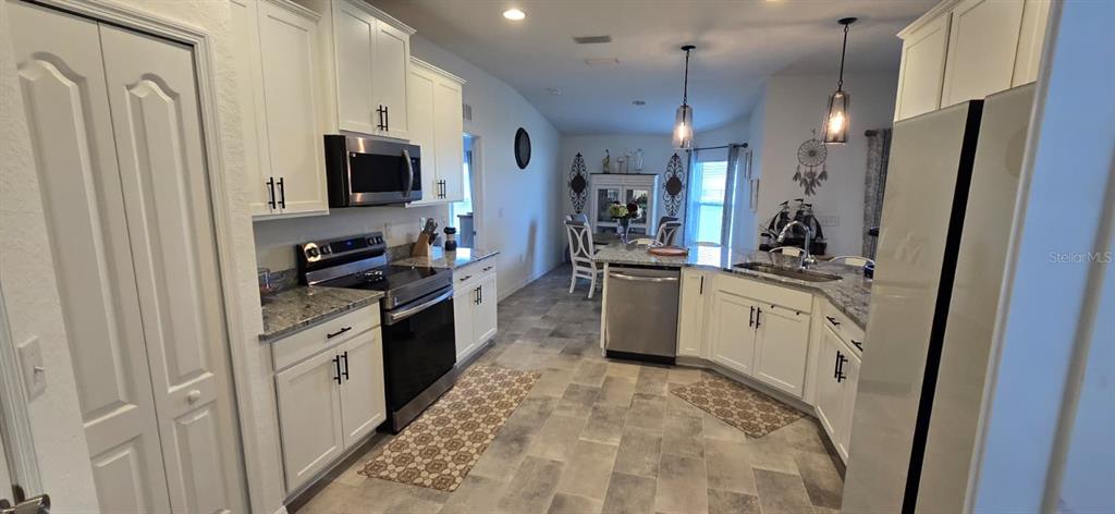 1108 Caloosa Ridge Way Babson Park, FL 33827 - Photo 11 of 29 a kitchen with white cabinets and appliances