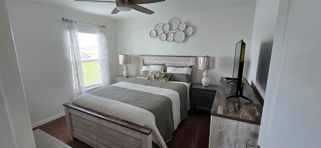 1108 Caloosa Ridge Way Babson Park, FL 33827 - Photo 16 of 29 a bedroom with a bed and a chandelier