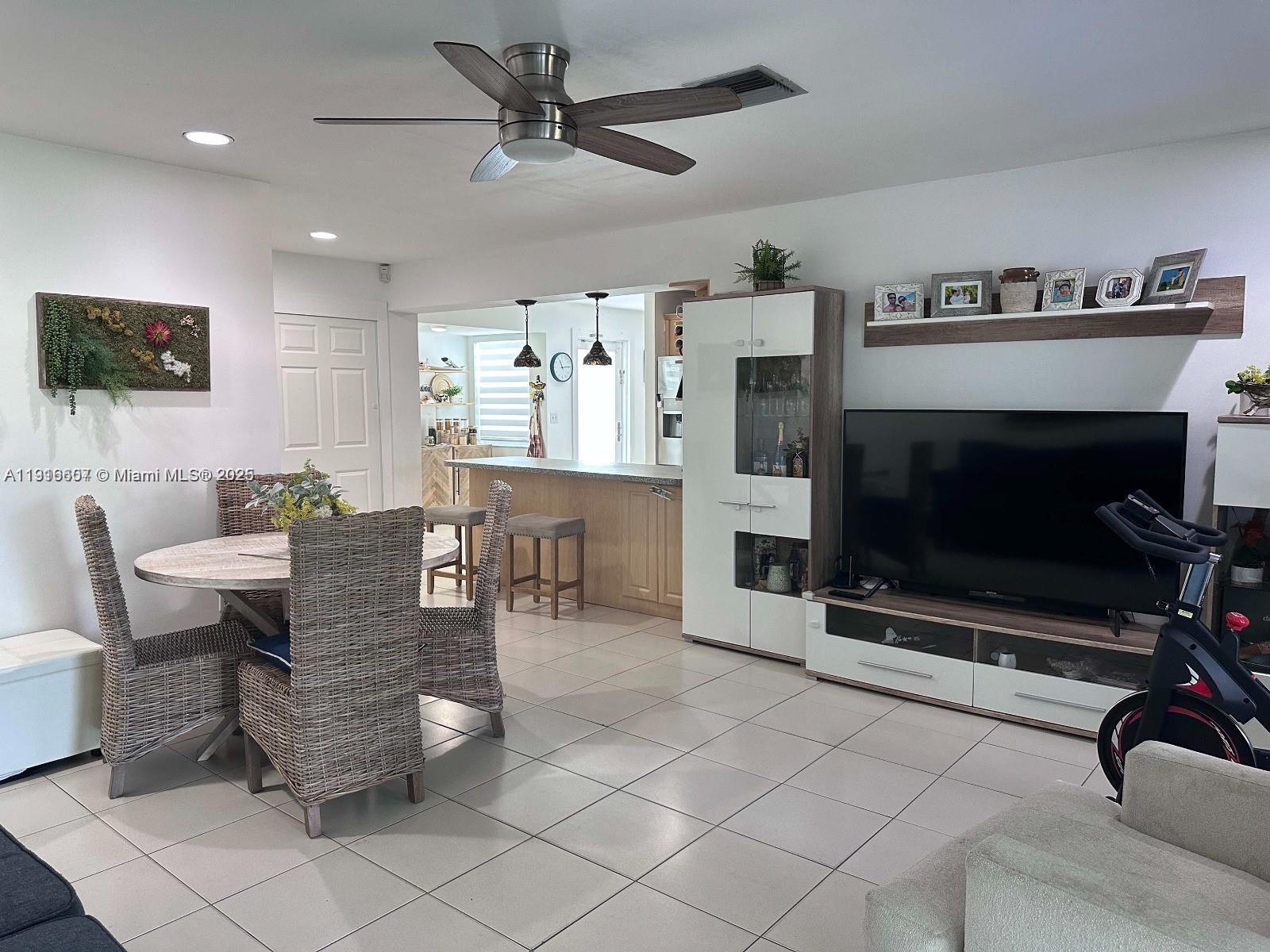 6174 West 14th Court, Unit 1 Hialeah, FL 33012 - Photo 16 of 24 a living room with furniture a flat screen tv and a fireplace