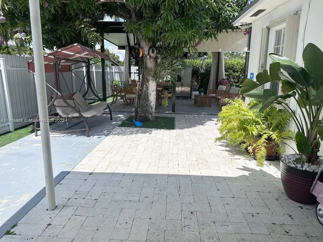 a view of backyard with garden and tall trees