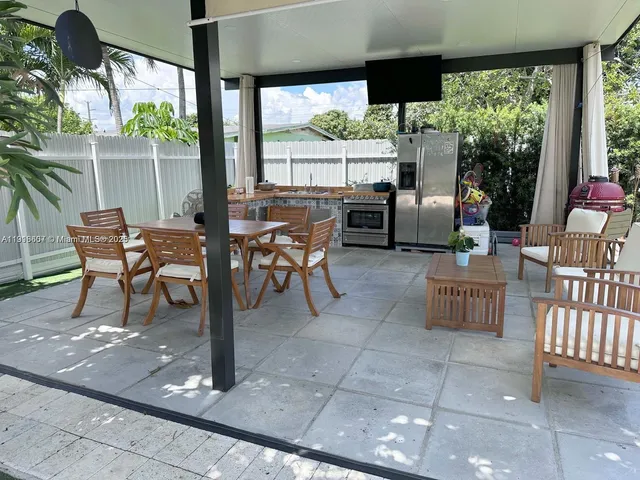 a view of a patio with a table chairs and a bed
