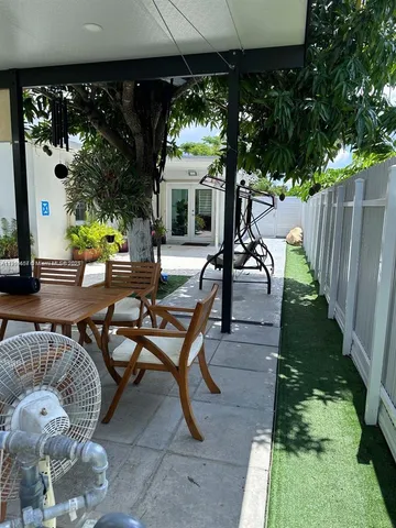 a living room with patio furniture and a garden