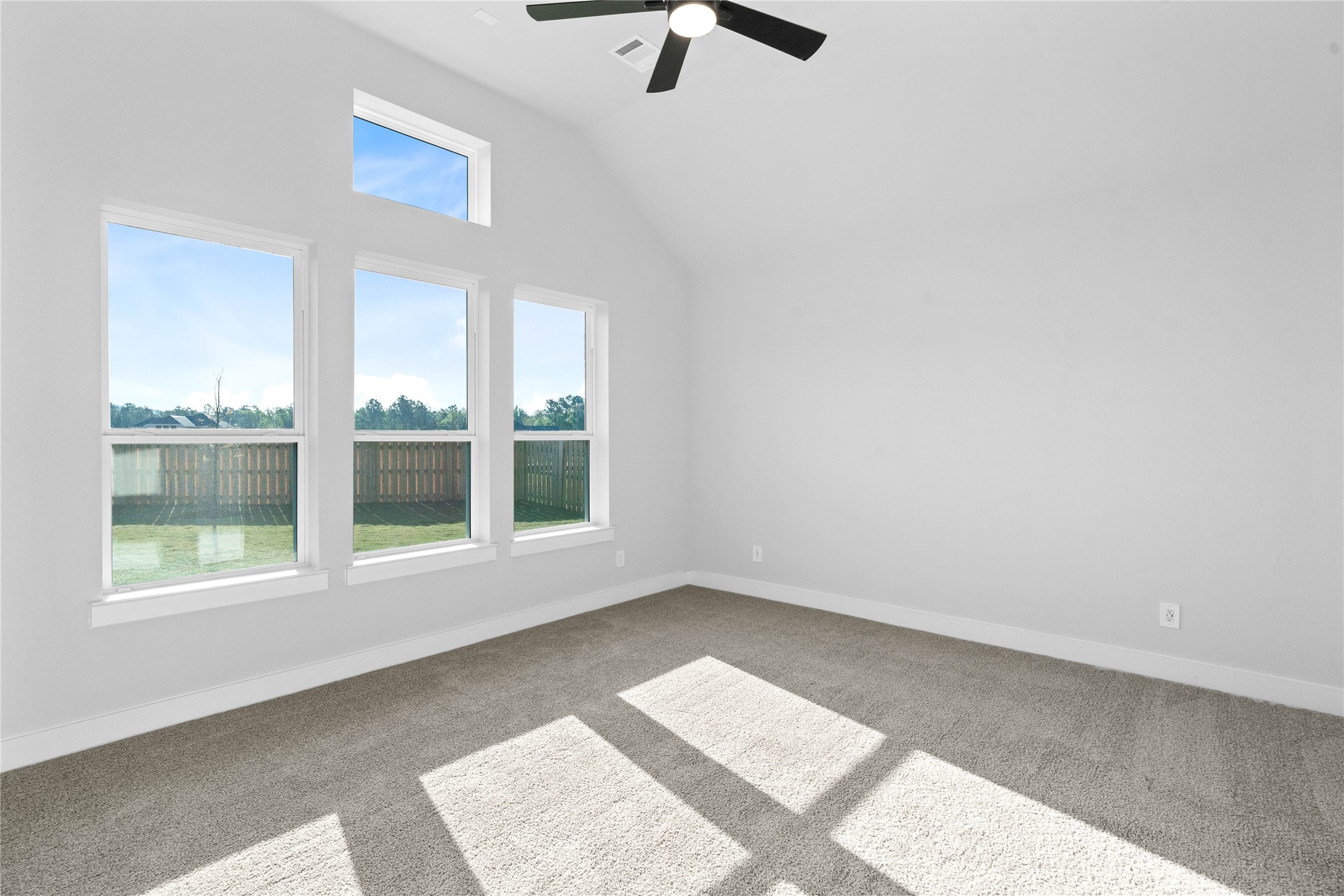 2114 Rowl Street Montgomery, TX 77316 - Photo 32 of 50 This spacious primary bedroom is an ideal private retreat, offering abundant natural light through multiple large windows and year-round comfort with a modern ceiling fan. The neutral color palette, including carpeting, creates a calm and inviting atmosphere that provides a perfect blank canvas for new owners to personalize.