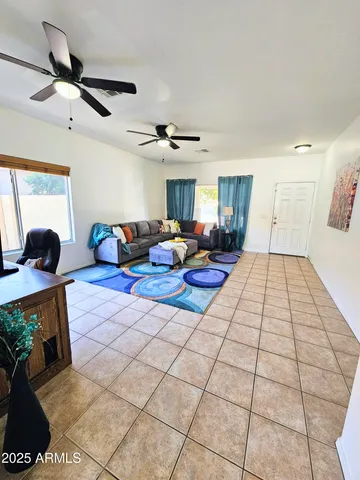 a living room with furniture and a ceiling fan