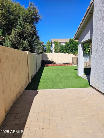 a view of a house with a yard and potted plants