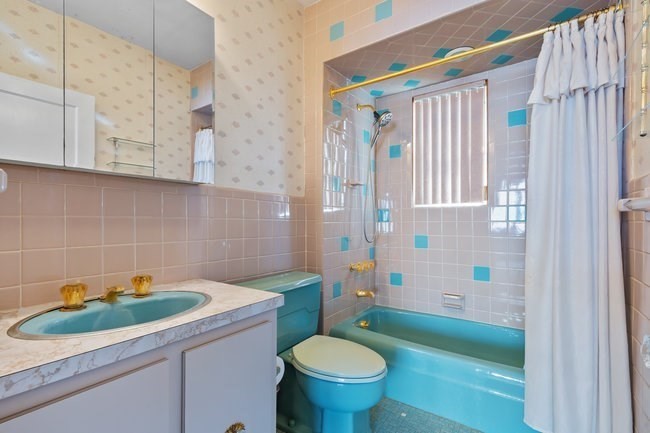 53 Windsor Street Everett, MA 02149 - Photo 15 of 20 a bathroom with a sink a toilet and shower curtain