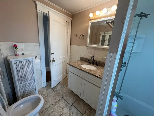 a bathroom with a granite countertop sink toilet and shower