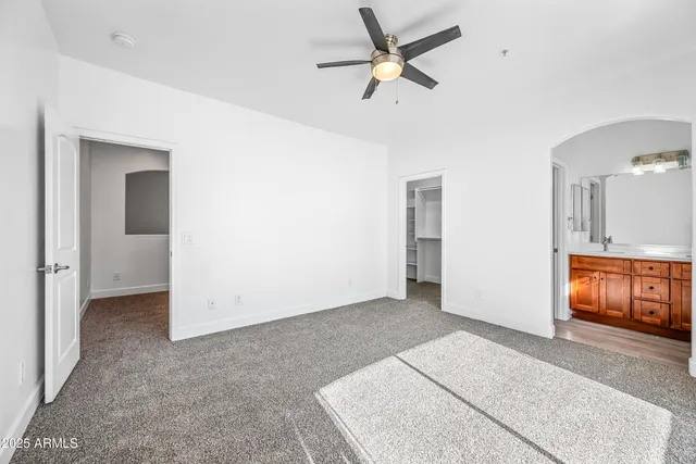 an empty room with closet and windows