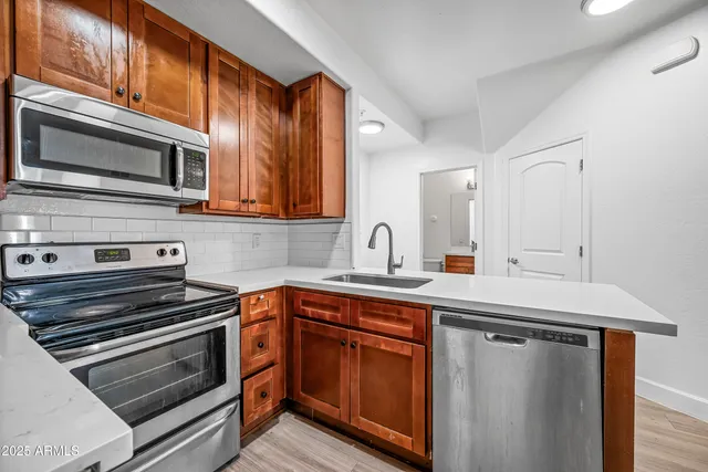 a kitchen with stainless steel appliances a stove microwave and sink