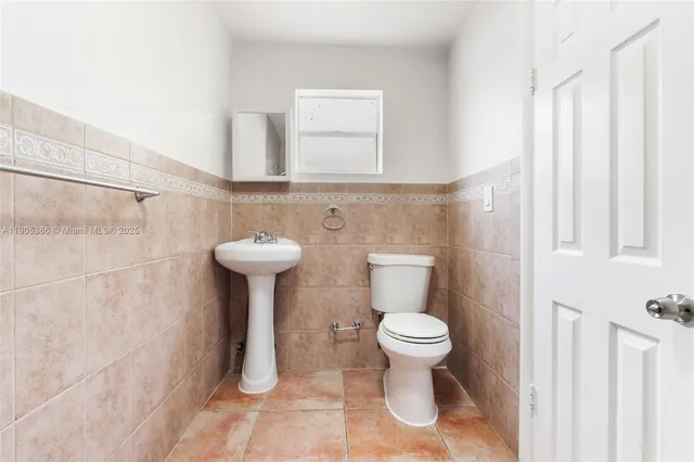 a bathroom with a sink toilet and a mirror