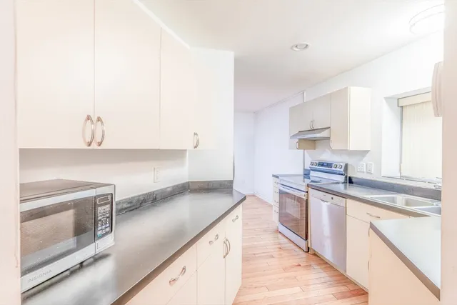 a kitchen with stainless steel appliances granite countertop a sink stove and cabinets