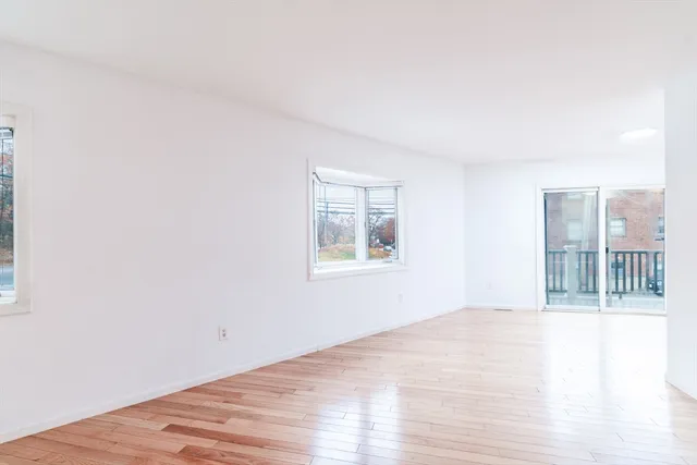 a view of a kitchen with wooden floor and a refrigerator