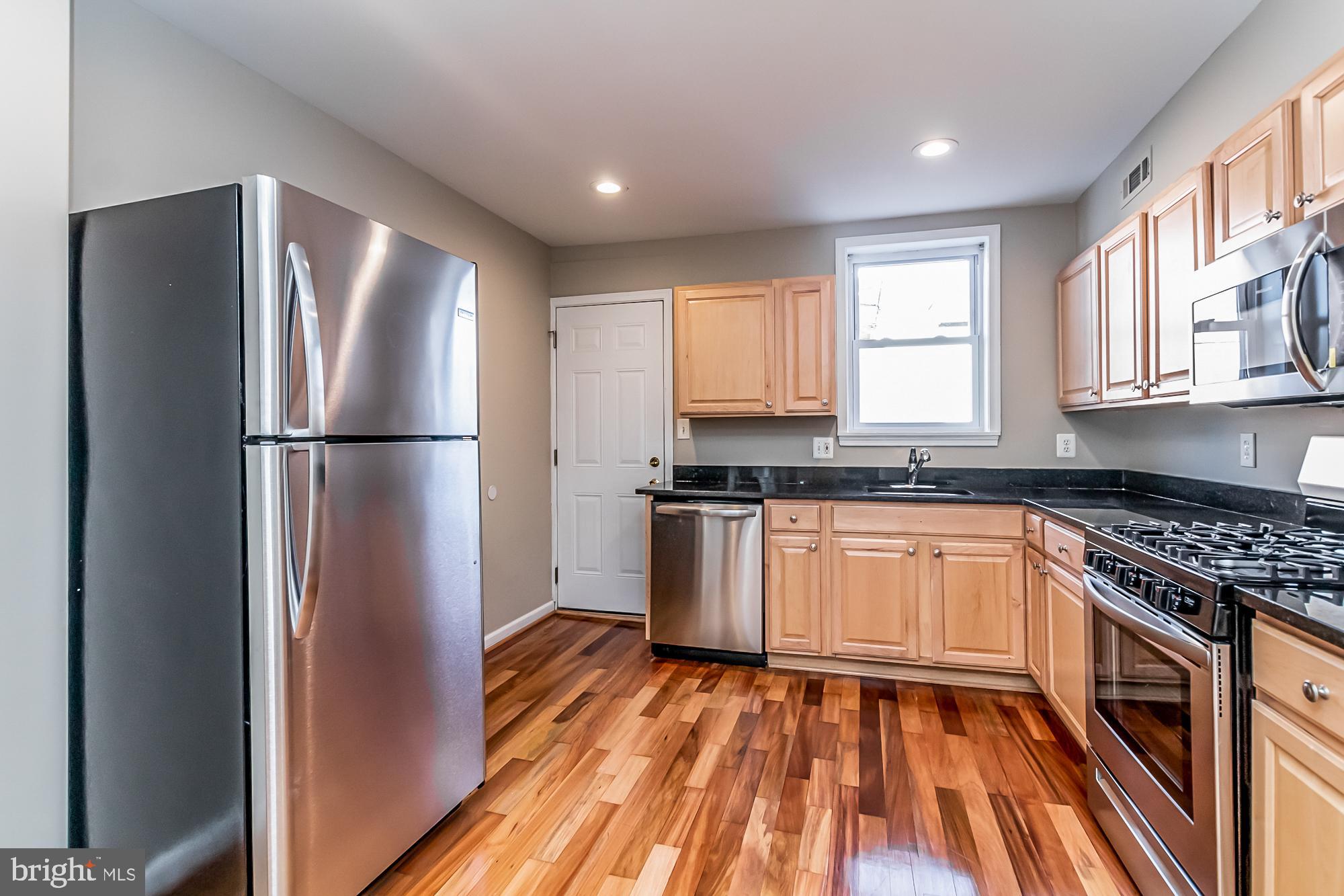 130 West Randall Street Baltimore, MD 21230 - Photo 12 of 30 a kitchen with granite countertop stainless steel appliances a refrigerator cabinets and wooden floor