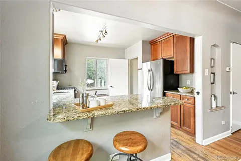 a kitchen with stainless steel appliances granite countertop a sink refrigerator and cabinets