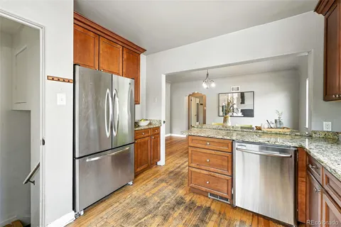 a kitchen with stainless steel appliances granite countertop a refrigerator and a stove top oven