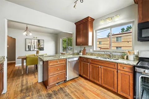 a kitchen with granite countertop a sink cabinets and wooden floor